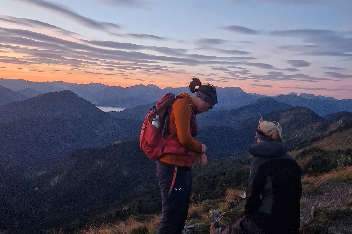 Mitarbeiterinnen des Instituts auf einem Berg bei Sonnenaufgang 