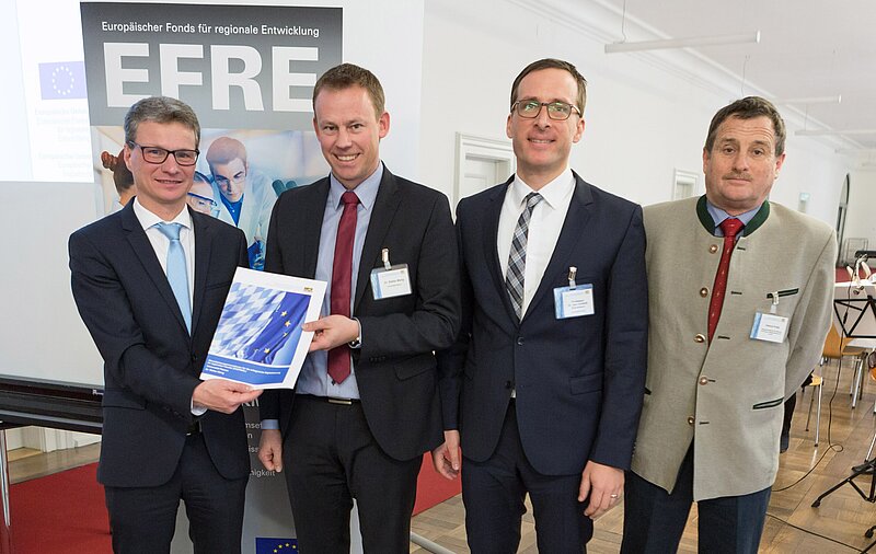 Förderbescheidübergabe in München am 23.02.2018 v.l.: Wissenschaftsstaatssekretär Bernd Sibler, Dr. Stefan Mang (CfM), Prof. Dr. Jan Schumann (Lehrstuhl Marketing und Innovation der Universität Passau) und Helmut Potje, Referent für EU-Wissenschaftsangelegenheiten am Bayerischen Staatsministerium für Bildung, Kultus, Wissenschaft und Kunst.